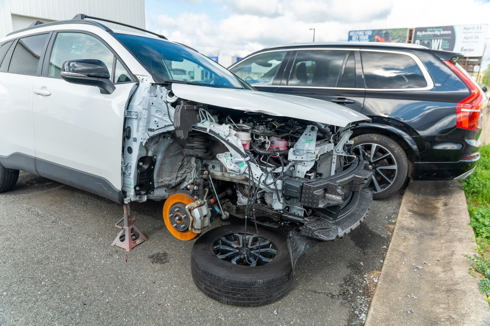 White Toyota Corolla Cross with severe front-end damage, before repair